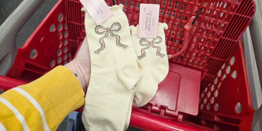 hand holding two pairs of bow socks