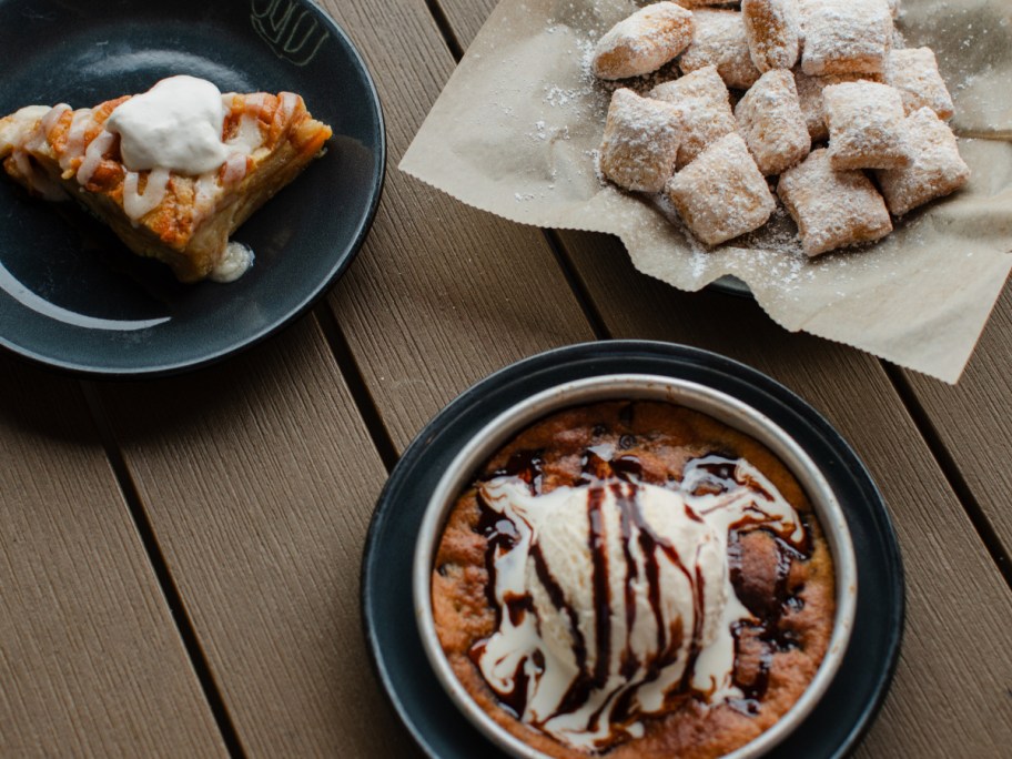 three desserts on wooden picnic table