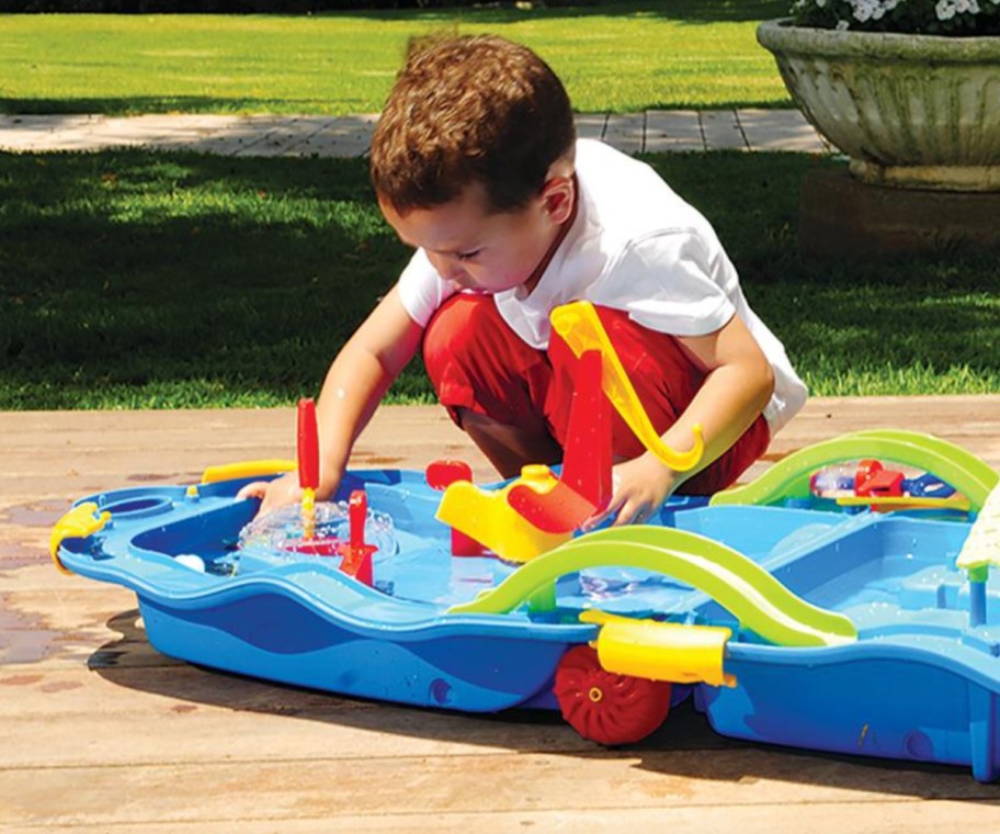 boy kneeling over water table