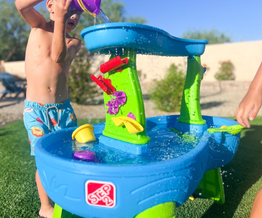 boy standing at step 2 rain showers water table