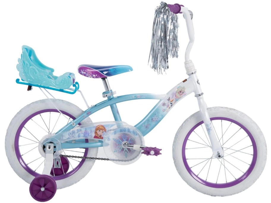 a girl's blue, purple, and white Disney Frozen bike with a doll carrier seat on the back and streamer son the handles