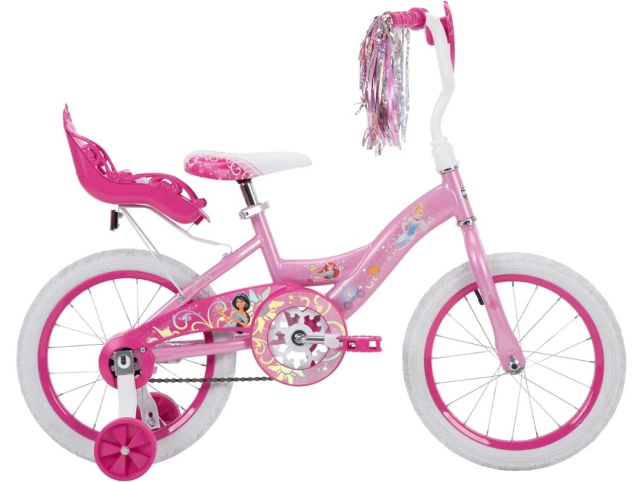 a girl's Disney Princess bike in pink and white with a doll carrier on the back and streamers on the handles