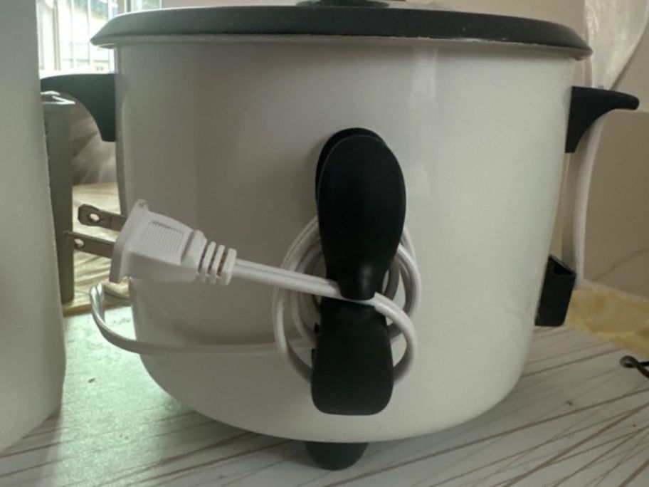A crockpot with a chord organizer on it 