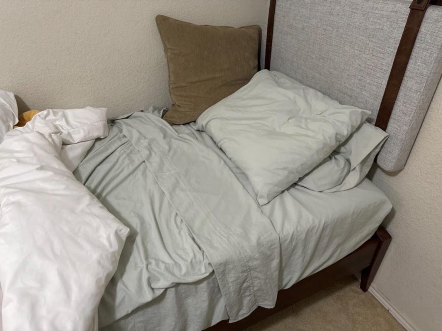 twin bed with sage colored sheets