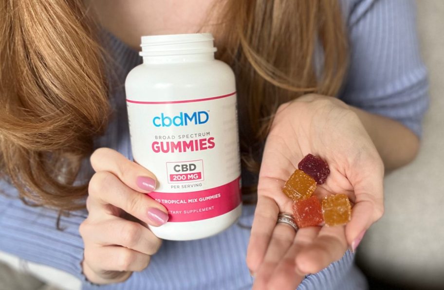 woman holding cbd gummies from cbdMD in her hand