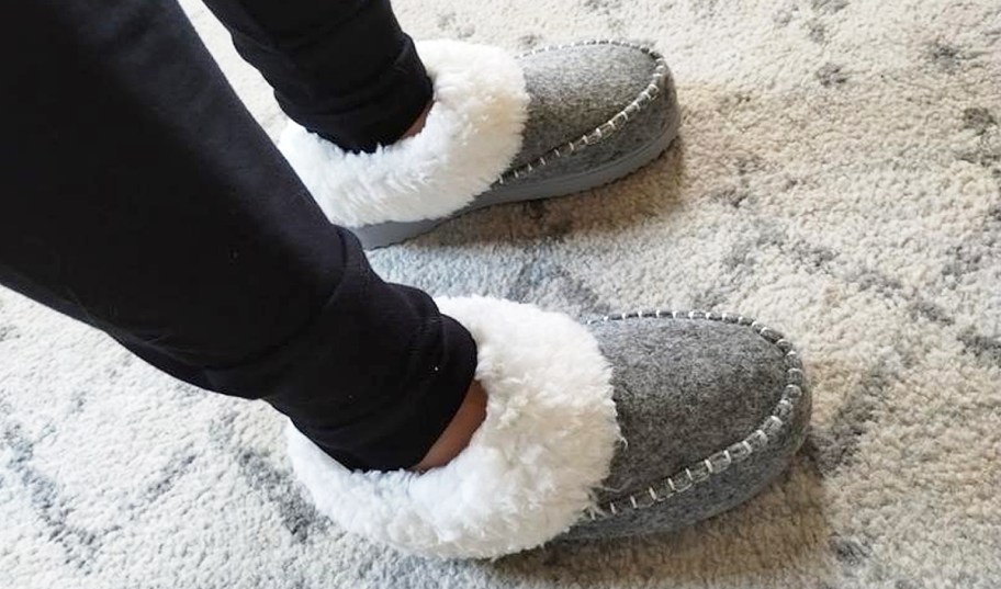 person wearing a pair of grey and white slippers