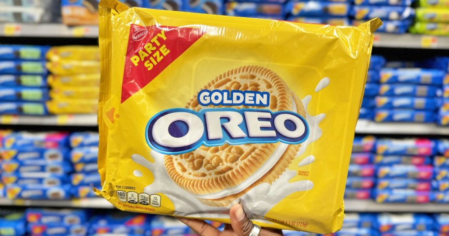 hand holding up a party-size pack of golden oreos in store