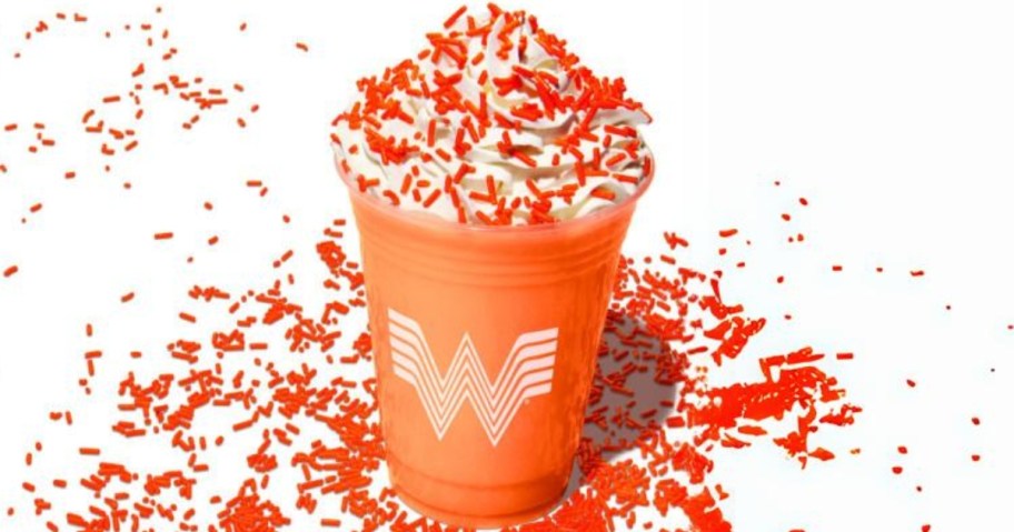 a Whataburger birthday shake in an orange cup with orange sprinkles around it