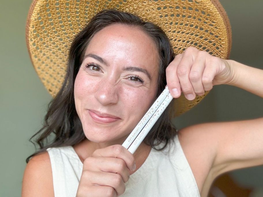 A woman holding 2 pens 