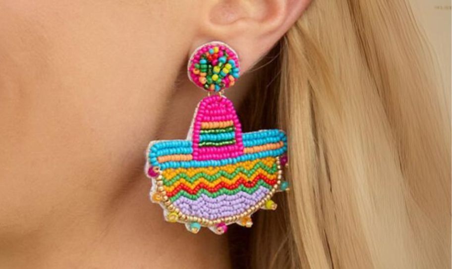 a womans ear shown wearing a beaded sombrero earring