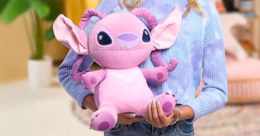 girl holding Just Play Disney Stitch Comfort Weighted 14" Angel Plush