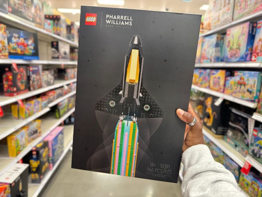 A person holding a LEGO Icons Over the Moon with Pharrell Williams Kit