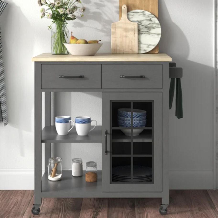 a graycolored rolling kitchen cart shown with serveware