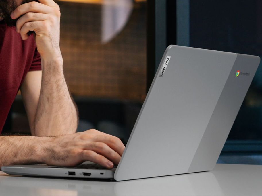 man's hands typing on the keyboard of a Lenovi Ideapad Slim 3