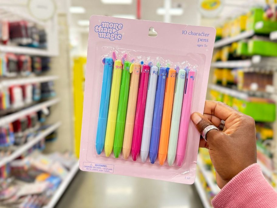 A hand holding a More than Magic Ballpoint Character Pen 10-Pack Set