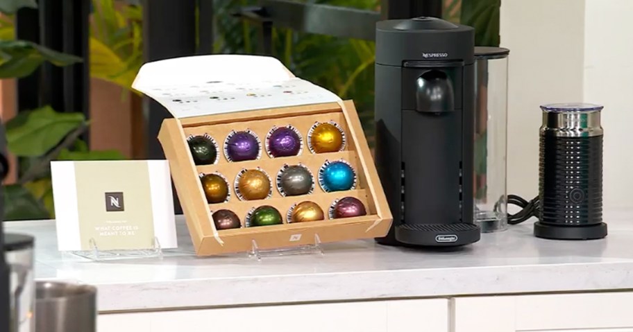 black nespresso maker with frother and set of coffee pods