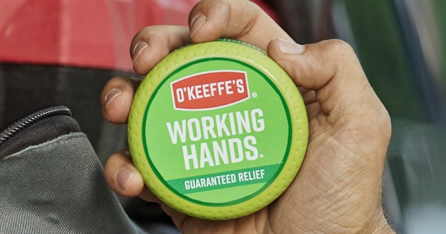 hand holding a container of O'Keeffe's Working Hands Hand Cream