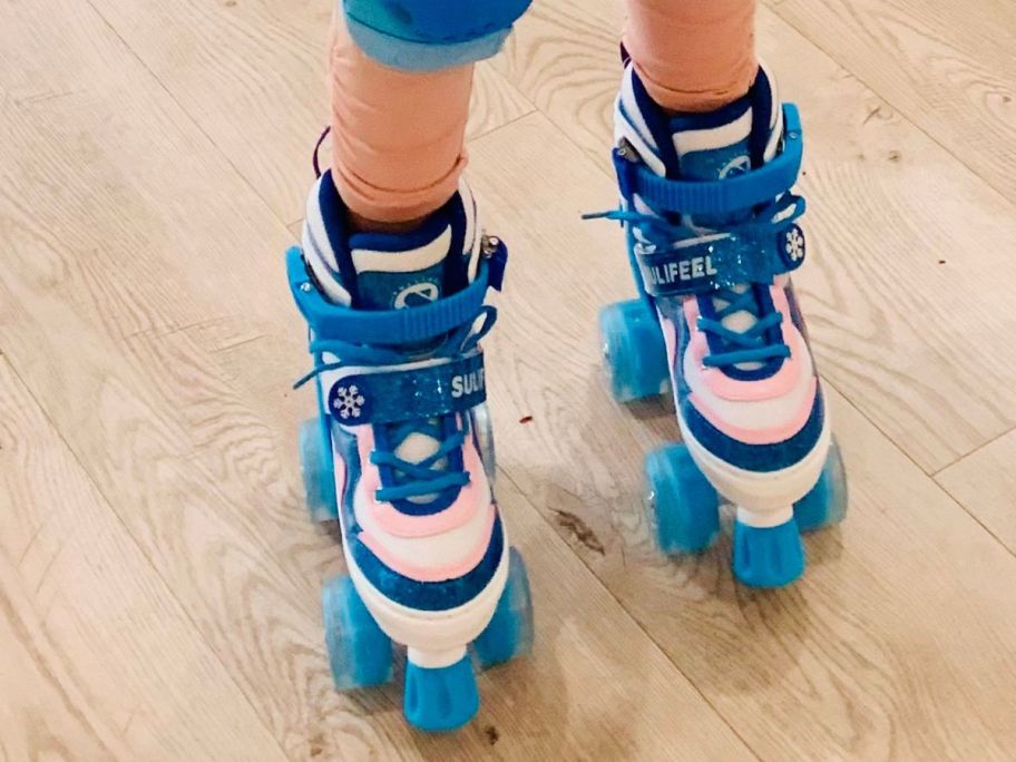 A child wearing a pair of adjustable roller skates in bright colors 