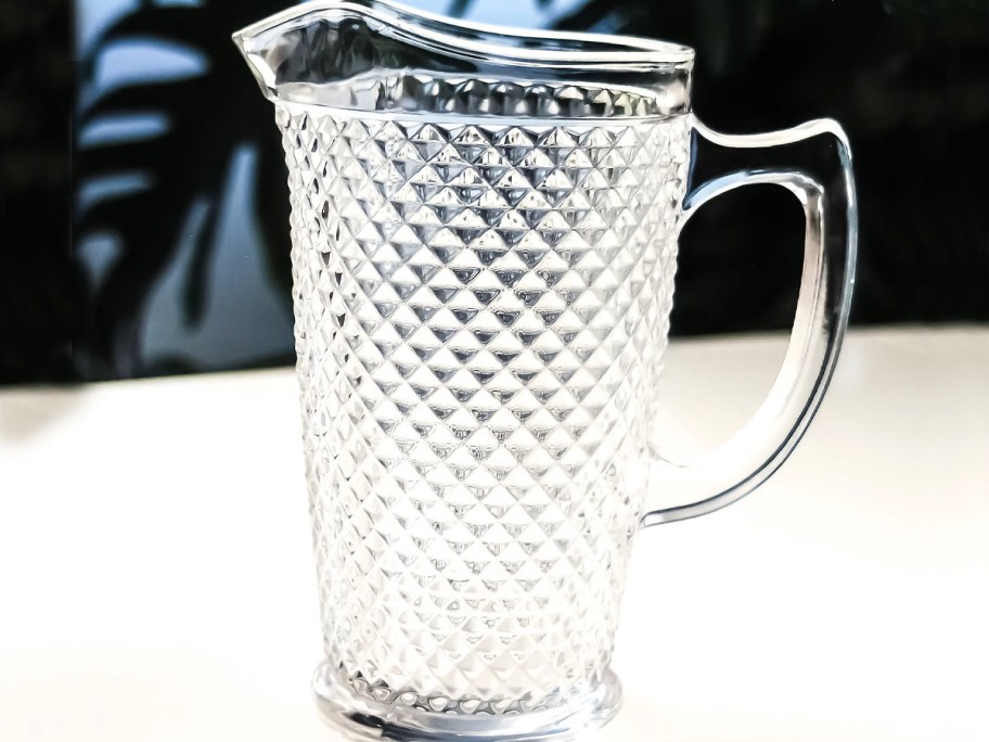 glass diamond cut pitcher sitting on table