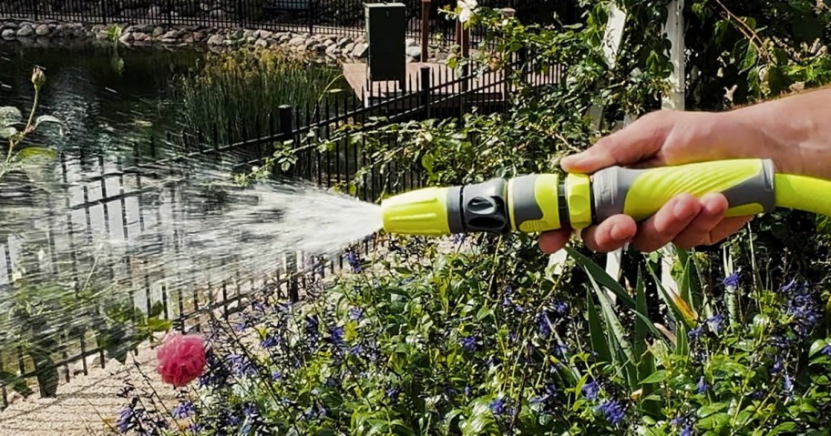 hand holding green and gray garden nozzle 