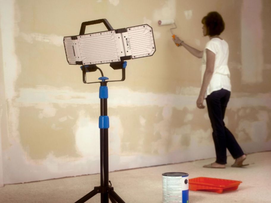 HART Multi-Directional LED 3-Head 7000 Lumen Work Light with Tripod, Adjustable, 7000 Lumens facing woman painting the wall