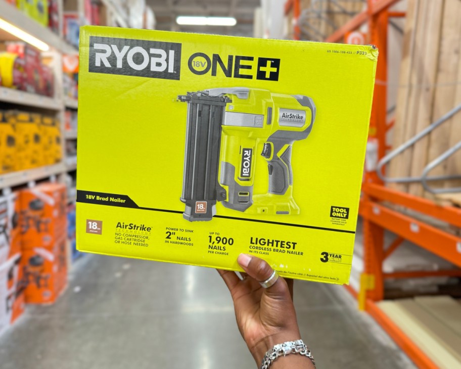 hand holding ryobi nail gun in box in store