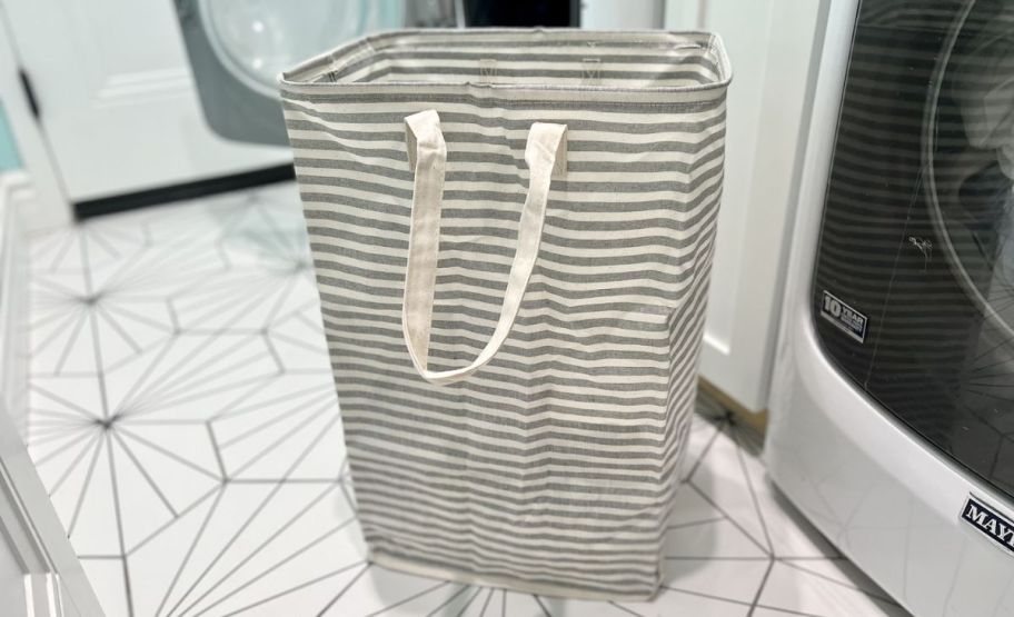 lifewit gray and white striped collapsible laundry hamper in front of a washer