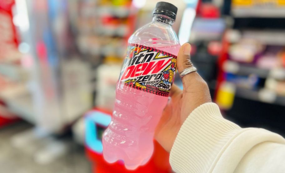 a womans hand holding a 20oz bottle of zero sugar mountain dew