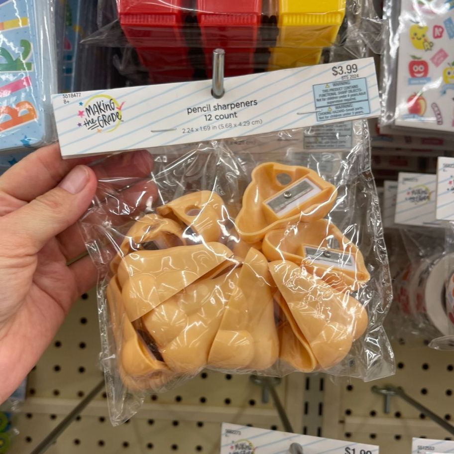 a womans hand holding a pack of nose shaped pencil erasers