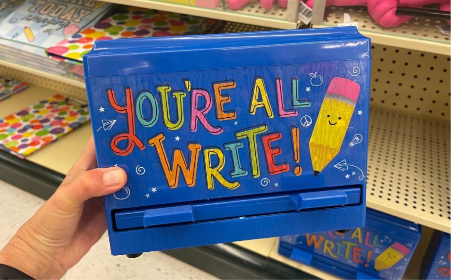 womans hand holding a pencil dispenser