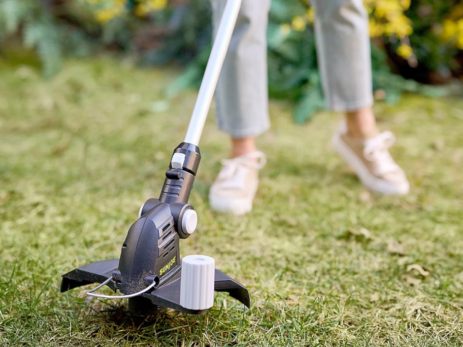 person using sun joe grass cutter