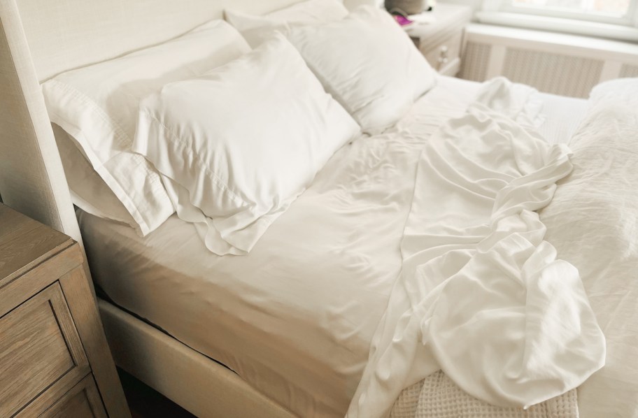 top view of side of unmade bed with white sheets