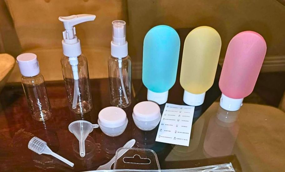 travel toiletry containers, funnels, spatula and labels on a glass tabletop