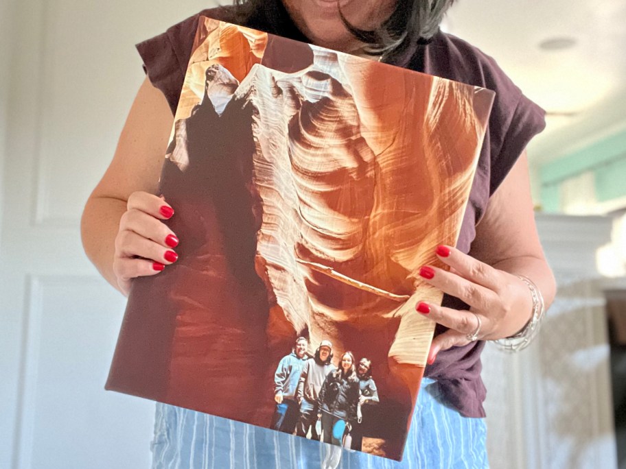 woman holding photo canvas of family 