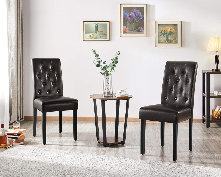 two brown leather dining chairs next to small table