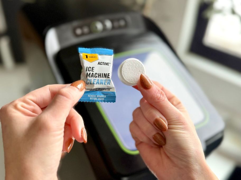 A person holding an Active Ice Machine cleaner tablet