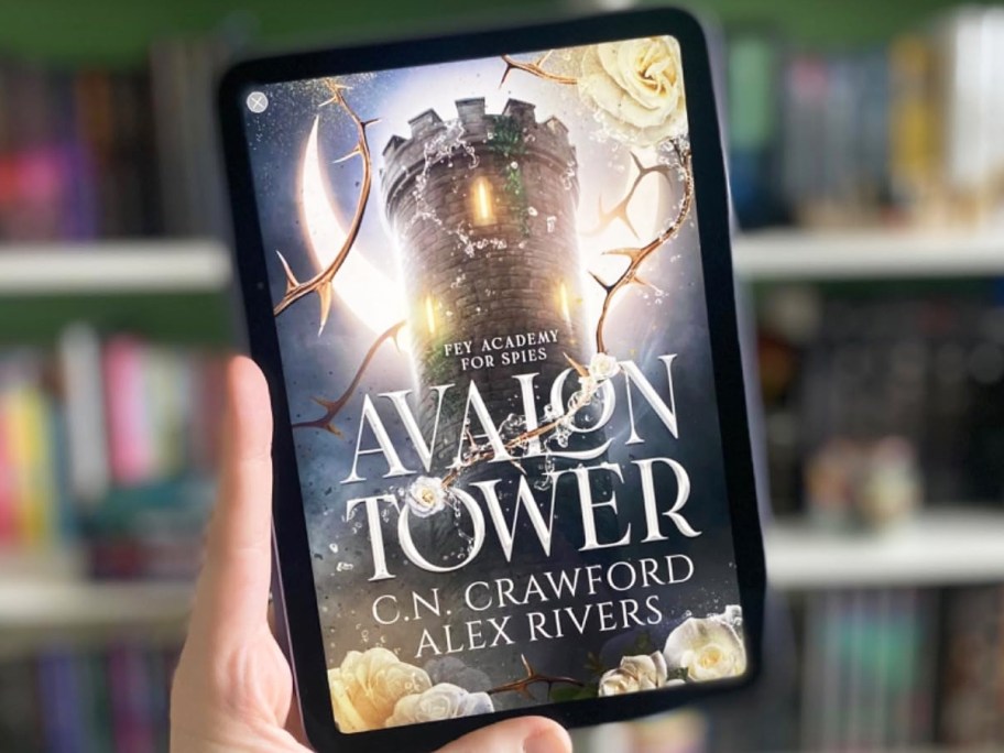 hand holding up tablet with Avalon Tower book cover