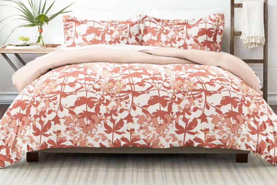 red floral print comforter and shams set on a bed