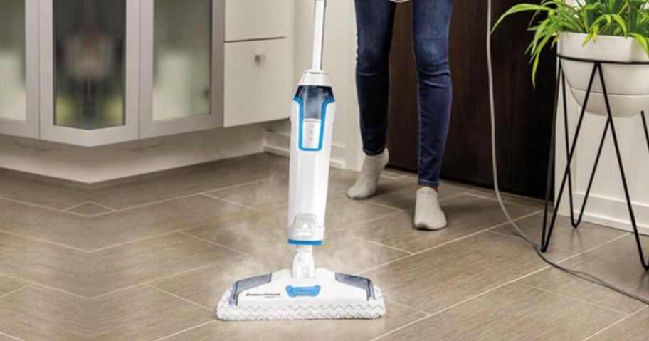 person using steam mop on floor