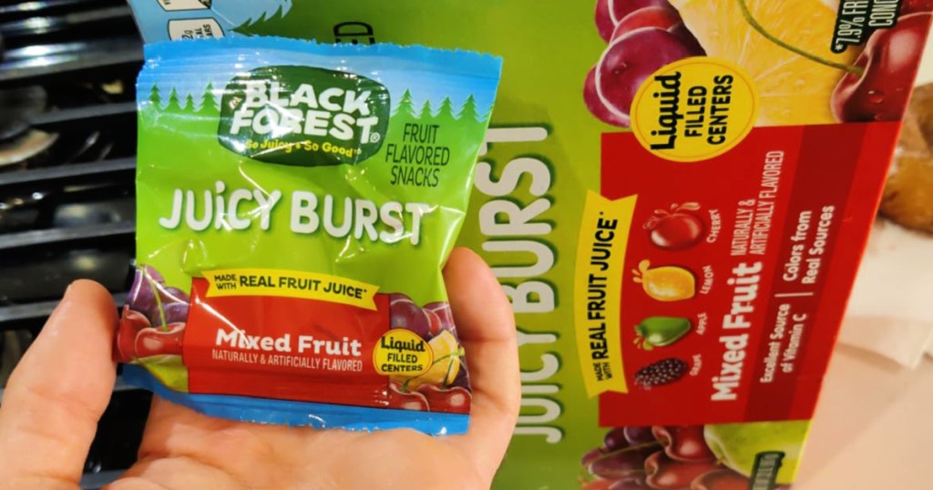 person holding single serve bag of Black Forest Juicy Bursts