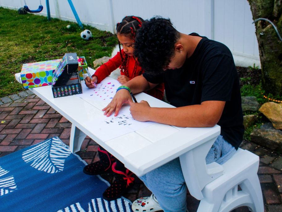 2 kids sitting at a picnic table