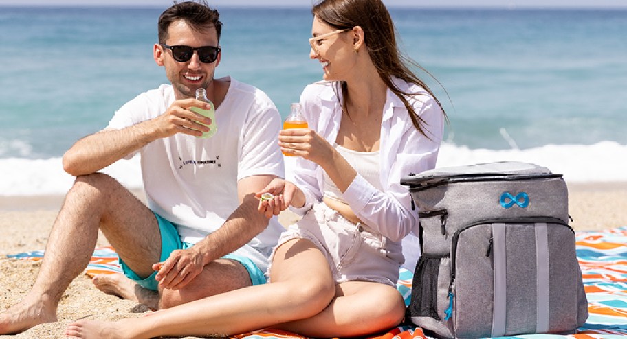 Couple using their backpack at the beach