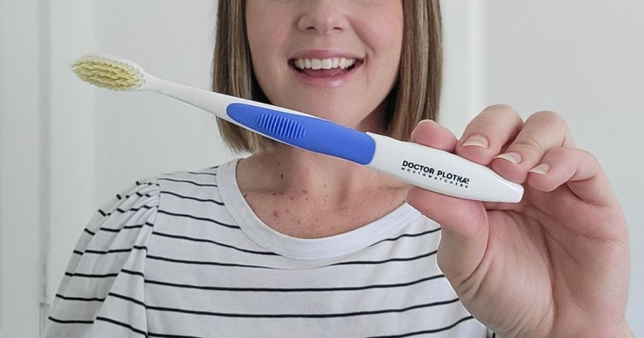 Woman holding a Dr Plotkas Mouthwatchers Toothbrush