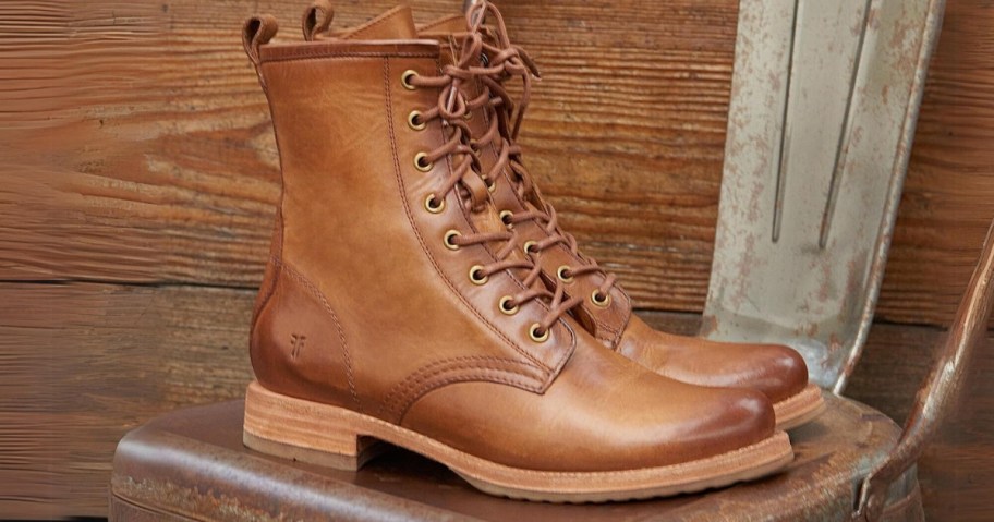 pair of light brown lace up leather boots sitting on a metal chair