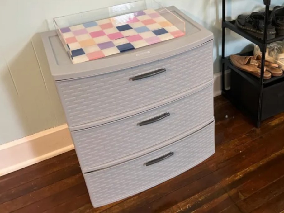 grey plastic 3-drawer storage organizer with a checkered acrylic tray on top