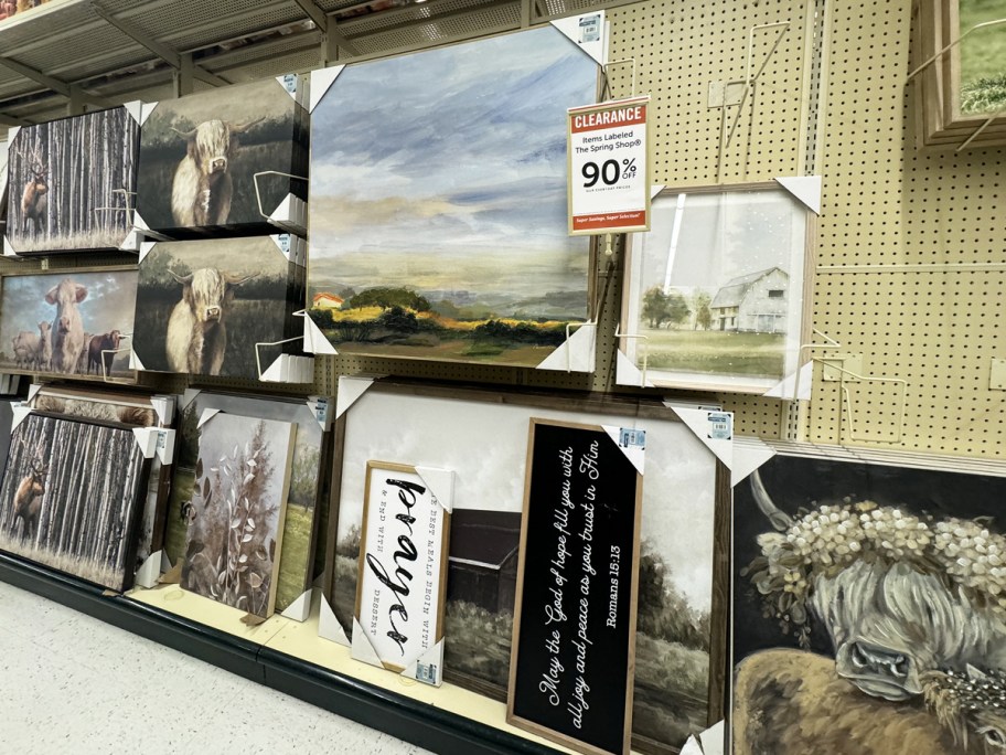 wall decor on display in store with 90% off clearance sign