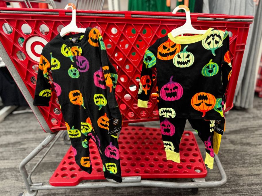 black pumpkin print pajamas hanging on the side of a target cart