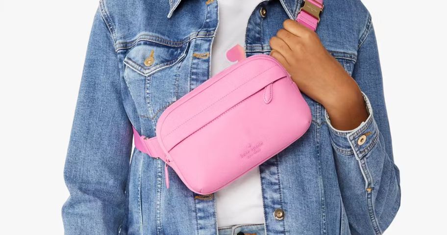 A woman wearing a pink Kate Spade belt bag