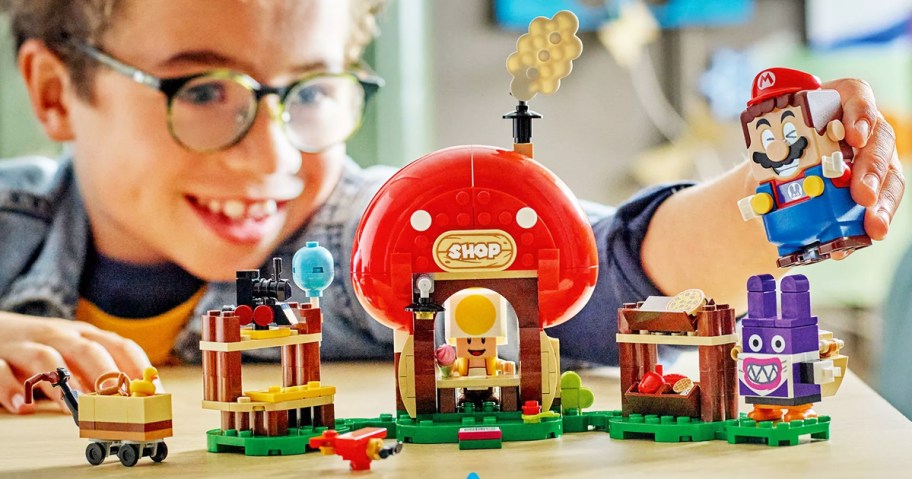 child playing with LEGO Super Mario Nabbit at Toad Shop Expansion Set