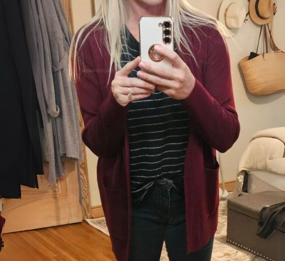 a woman taking a selfie wearing a burgundy colored open front cardigan